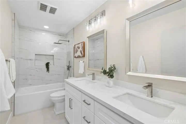 Quartz countertops, elegant soft-close cabinetry, and shower wands elevate all bathrooms with both style and function. The primary suite is further enhanced by a beautifully remodeled closet showcasing tailored cabinetry by Closet Evolution