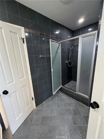 Jack and Jills bathroom with large stall shower w/floor to ceiling tile.