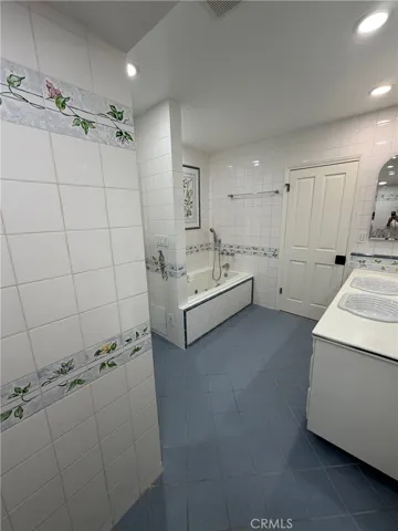 Master bathroom has a spa tub and recessed lighting