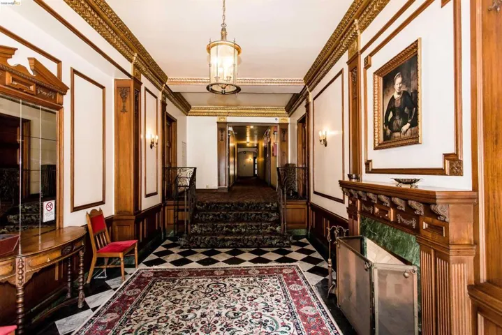 Corridor featuring wainscoting, crown molding, a decorative wall, and hanging lights