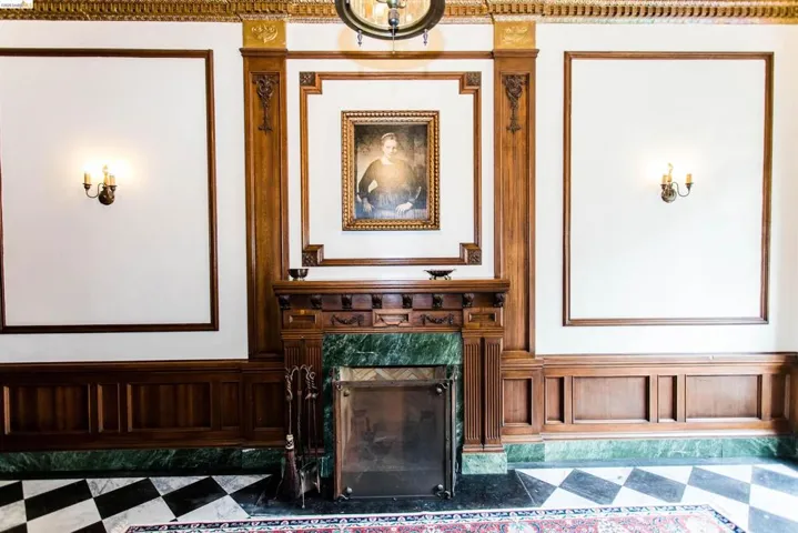 Living room with a fireplace, a wainscoted wall, and a decorative wall