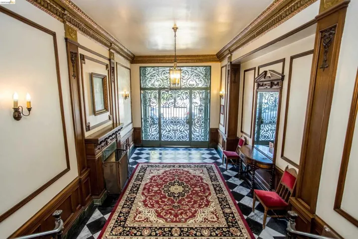 Doorway to outside featuring a decorative wall, wainscoting, and crown molding