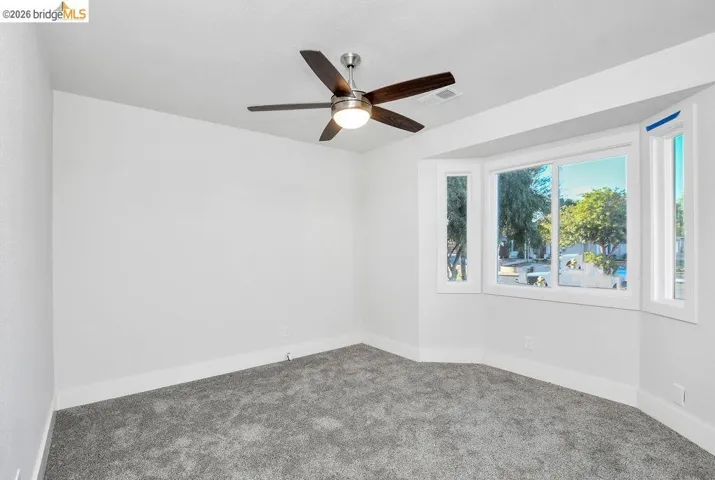 Empty room featuring carpet flooring and ceiling fan