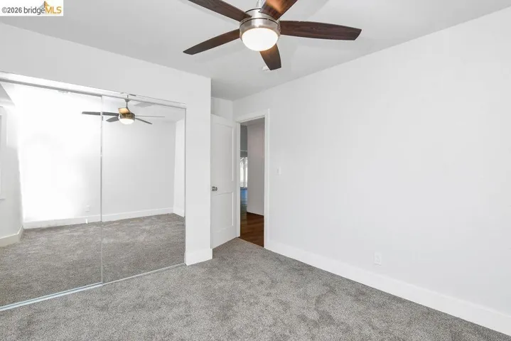 Unfurnished bedroom with carpet flooring, a closet, and a ceiling fan