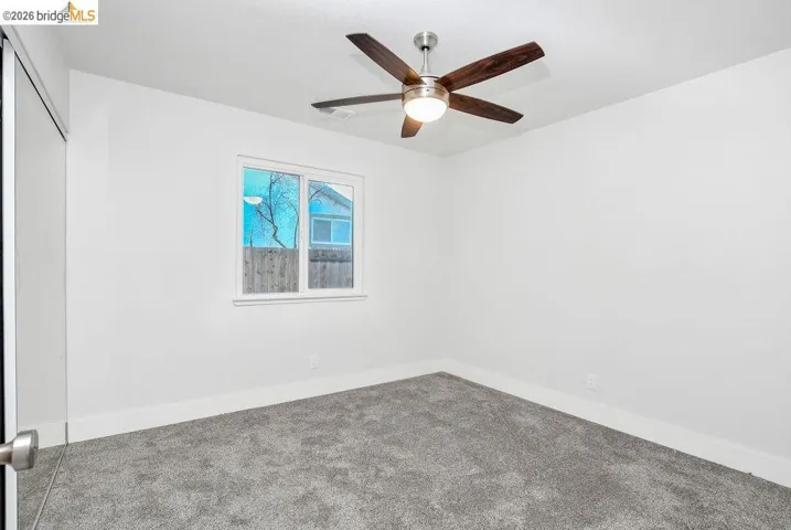 Spare room featuring carpet and a ceiling fan