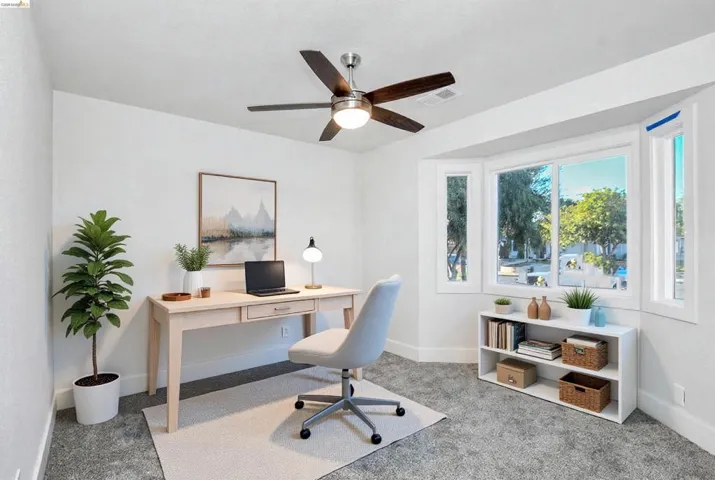 Home office featuring light colored carpet and ceiling fan