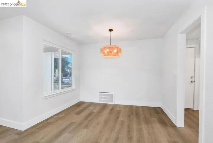 Unfurnished dining area featuring light wood-style flooring and baseboards