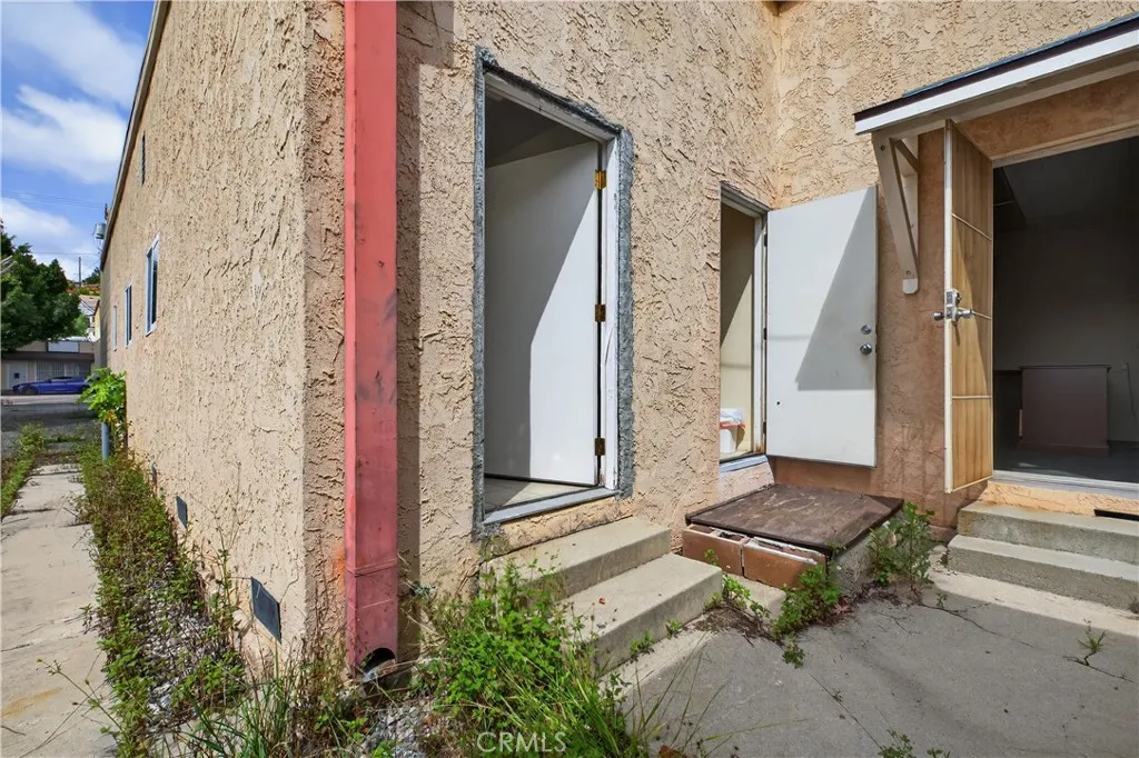 BACK ACCESS AND EXIT. ANOTHER AREA ON RIGHT AND ACCESS TO BASEMENT FOR STORAGE