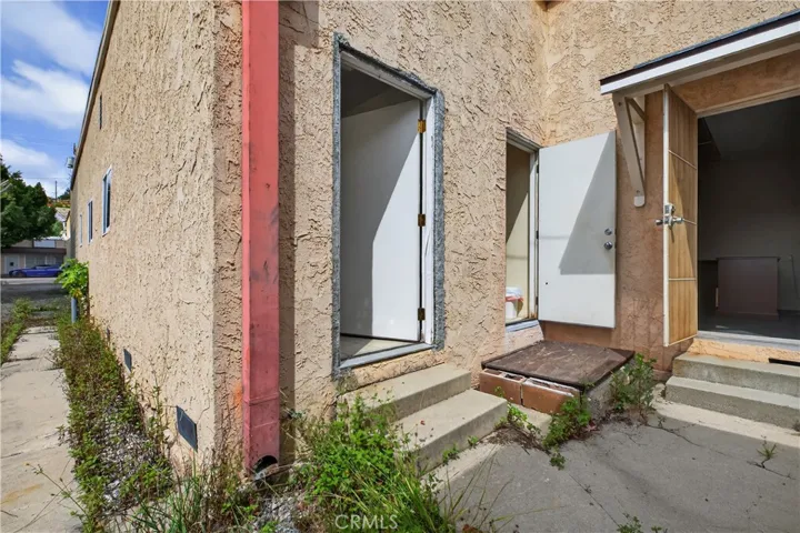 BACK ACCESS AND EXIT. ANOTHER AREA ON RIGHT AND ACCESS TO BASEMENT FOR STORAGE