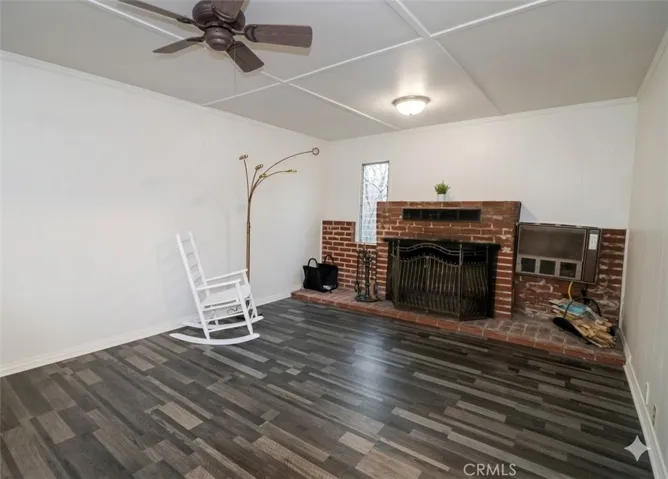 Living room with cozy fireplace and ceiling fan