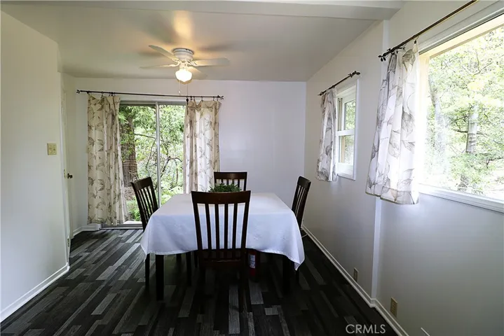 Extra spacious dining area with ceiling fan, forest views and slider to creek