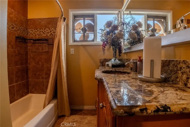 Stylish bathroom with gold foil textured glass vessel sink, modern finishes, and built-in iPhone dock for music