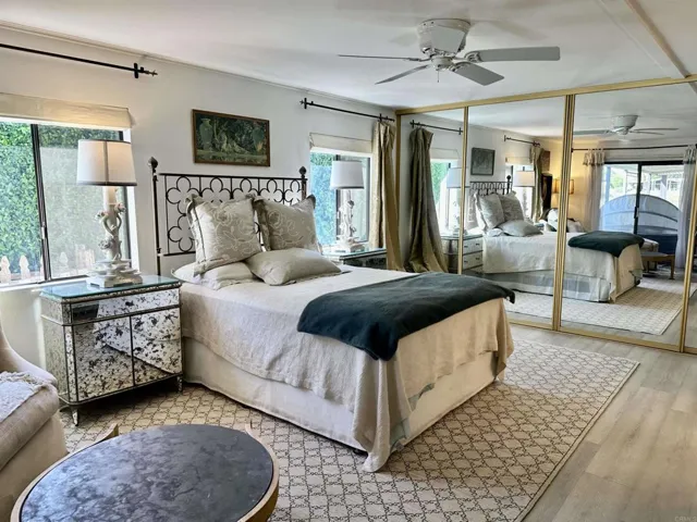This large primary bedroom has 13'4" of mirrored closets, a sitting area, & a slider to patio.
