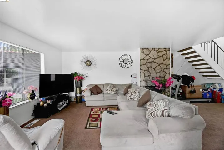 Carpeted living area featuring stairway