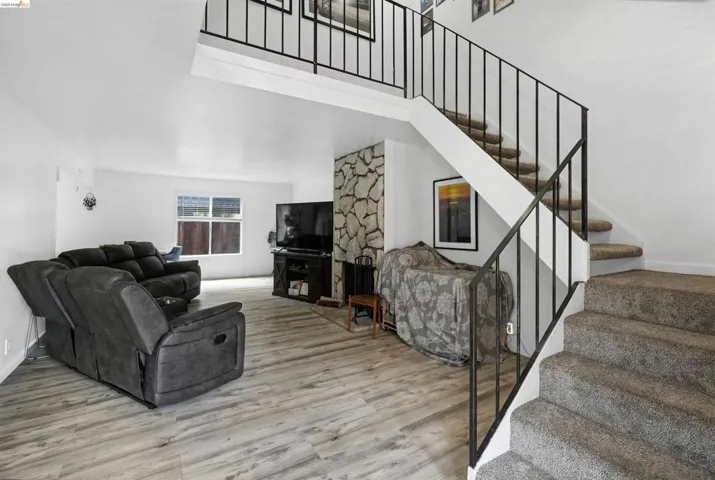 Living area featuring light wood-style floors and a high ceiling