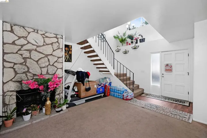 Foyer entrance with carpet floors and a stone fireplace