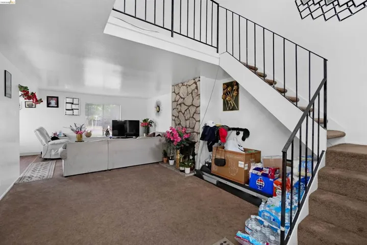 Living area with carpet and stairway