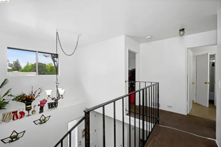 Corridor featuring a chandelier, an upstairs landing, and carpet floors
