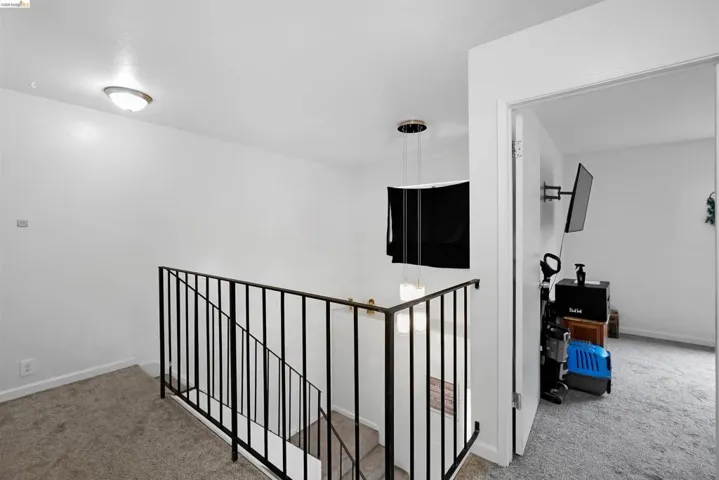 Hall featuring carpet floors and an upstairs landing