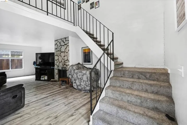Stairs with wood finished floors and a high ceiling