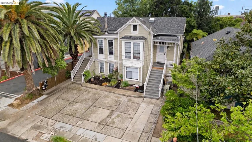 View of front of home featuring stairs and a shingled roof