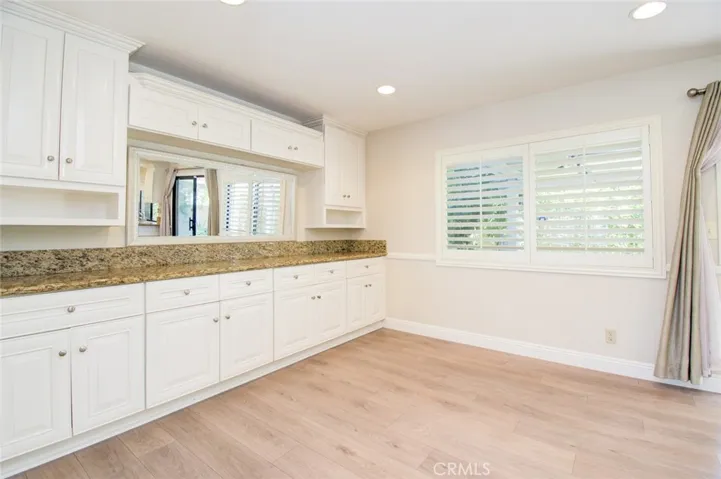 The family room with build-in cabinets, a great extension of the adjacent kitchen. Recess ceiling lights and wood shutter.