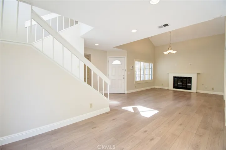 The view of the living room from the dining room showing the front door.