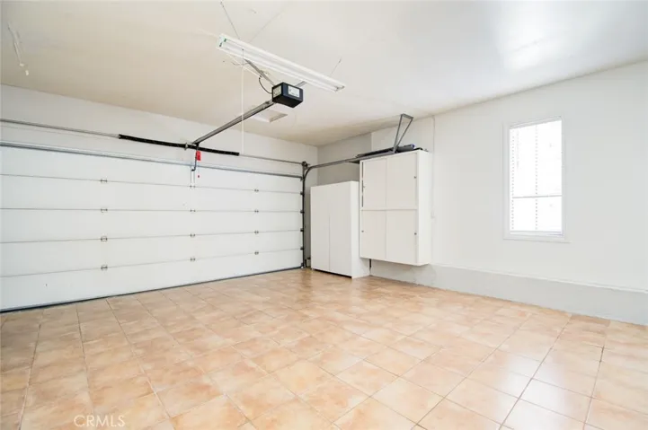 2 car garage with cabinets for storage.