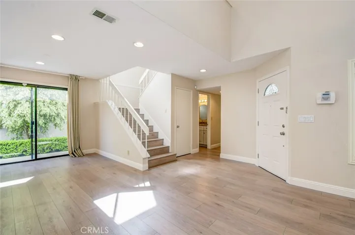 The dining room and front door. A powder room is next to the staircase while a laundry closet is opposite of the powder room.