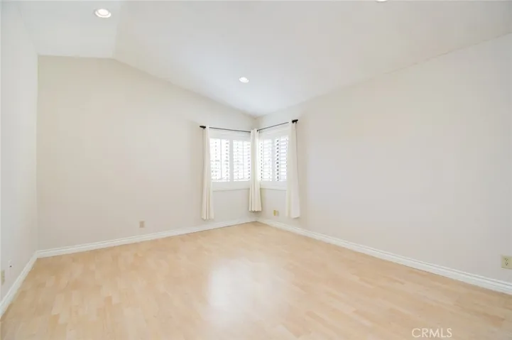 The light and bright primary bedroom suite with high ceiling and laminated floor.