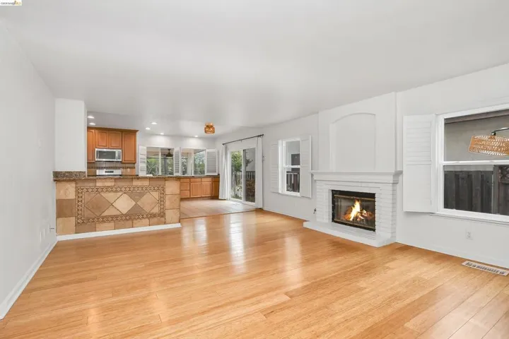 Unfurnished living room with light wood finished floors, a fireplace, and recessed lighting
