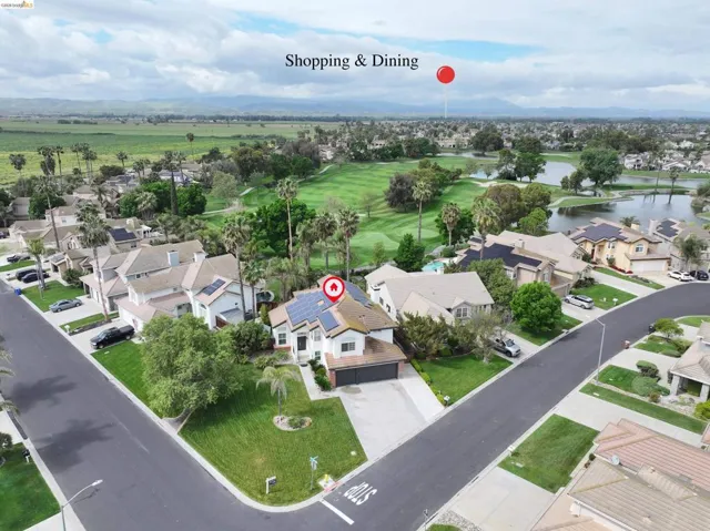 Aerial view of residential area featuring a water and mountain view and a golf course