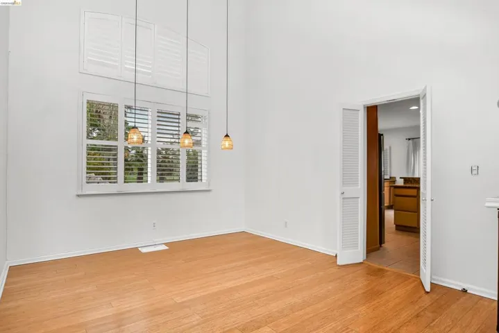 Empty room with a high ceiling and light wood-style floors