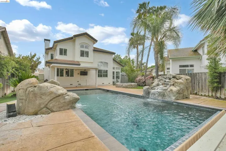 Back of house with a fenced backyard, a chimney, a patio area, stucco siding, and a tile roof