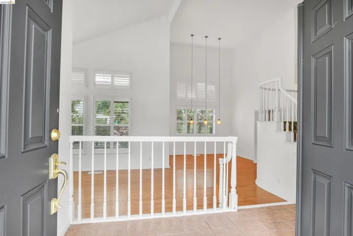 Foyer featuring vaulted ceiling and light tile patterned floors