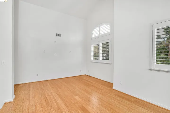 Unfurnished room featuring lofted ceiling and light wood-type flooring