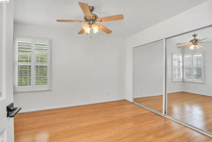 Unfurnished bedroom featuring ceiling fan, wood finished floors, and a closet