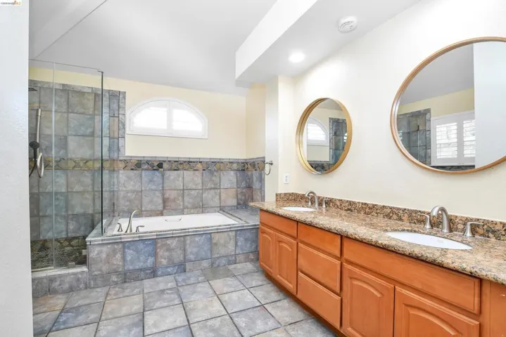 Full bathroom with a garden tub, double vanity, and a stall shower