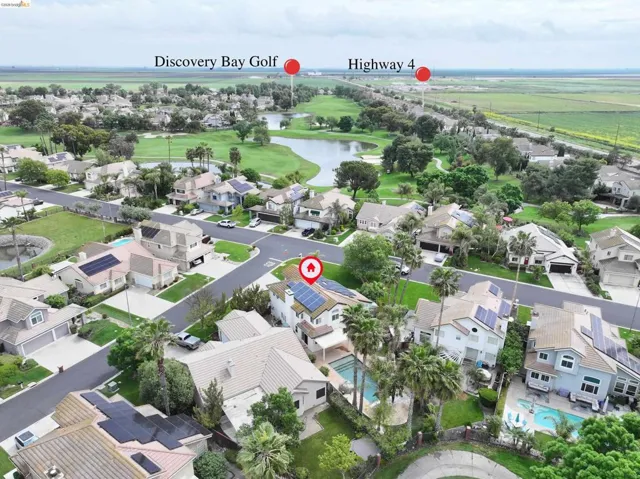 Aerial perspective of suburban area featuring a large body of water and a local golf course