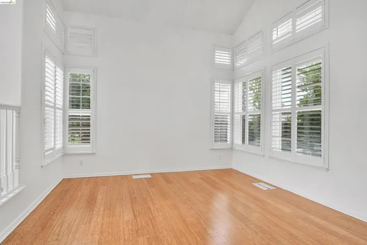 Empty room featuring lofted ceiling and light wood-style floors