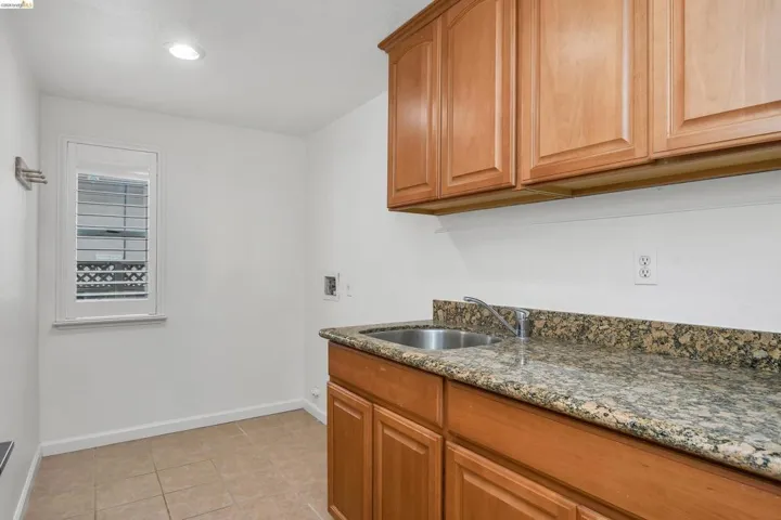 Laundry room featuring hookup for a washing machine, cabinet space, and light tile patterned floors