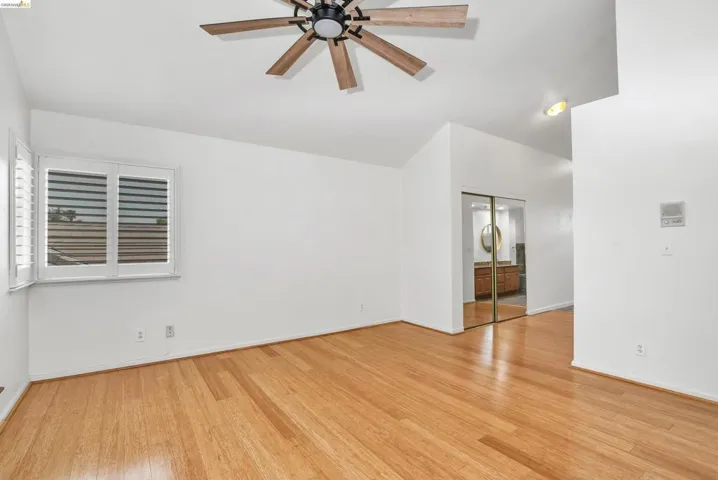 Spare room featuring ceiling fan, light wood-type flooring, and lofted ceiling