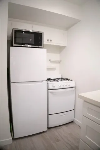 Kitchen equipped with a full set of appliances including a refrigerator, gas range, and microwave.