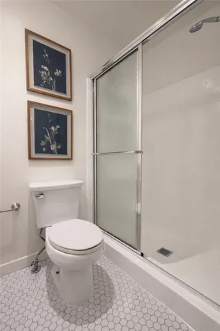Bathroom with clean finishes, updated fixtures, and a glass-enclosed shower.