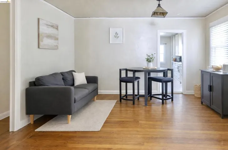 Living room featuring light wood-style floors, healthy amount of natural light, and crown molding