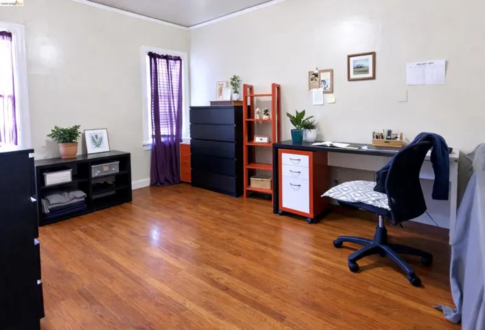 Office area featuring dark wood-type flooring and ornamental molding