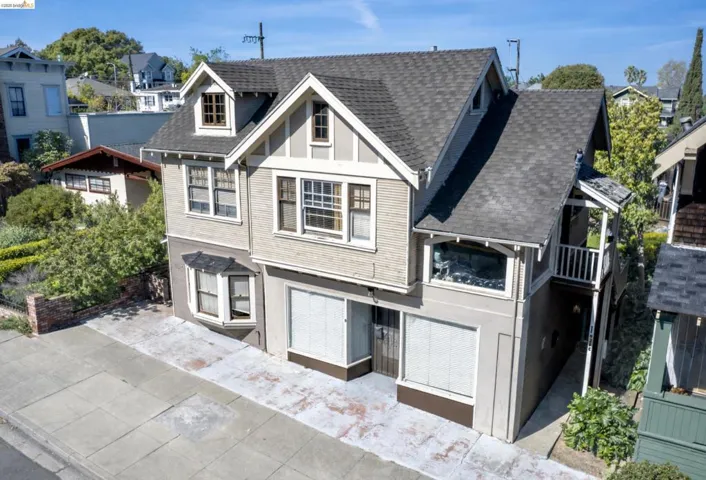 View of front facade with a balcony, roof with shingles, and a residential view