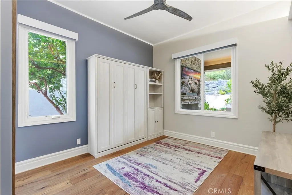Guest bedroom with Murphy bed and wood flooring