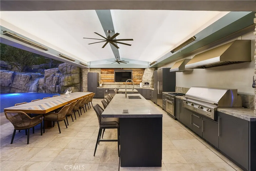 Kitchen with BBQ, smoker, pizza oven sink, dishwasher, full size refrigerator 2 drawer fridge, ice maker TV, and large island