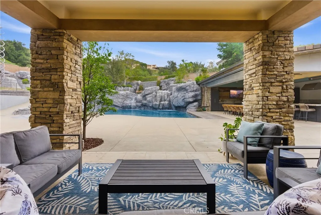 Covered outdoor patio overlooking resort pool and backyard